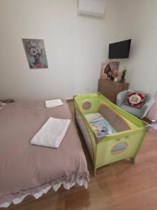 ein Schlafzimmer mit einem Bett und einem Babybett in der Unterkunft Maison Luisa in Pozzuoli
