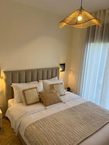 una camera da letto con un letto grande con lenzuola e cuscini bianchi di Dar Jawhara a Marrakech