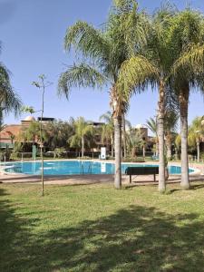 un parco con palme e una piscina di Dar Jawhara a Marrakech