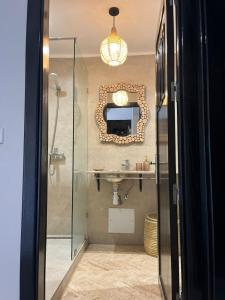 bagno con lavandino e specchio a parete di Dar Jawhara a Marrakech