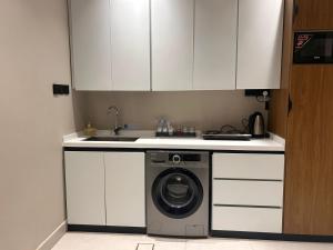 a kitchen with a washing machine and a sink at هيلز للشقق المخدومة in Hail +16 photos