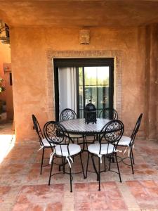 un tavolo nero e sedie su un patio di Dar Jawhara a Marrakech Altre 48 foto