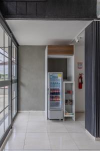 Una habitación vacía con un refrigerador con bebidas dentro. en Hotel Stadio Cali, en Cali