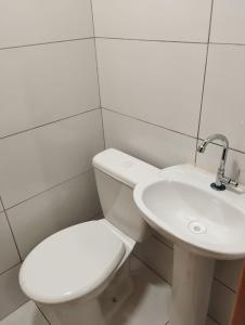 een witte badkamer met een toilet en een wastafel bij Alojamento seu Jorge in Campinas +16 foto's