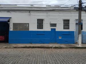 een blauw-wit gebouw met een blauwe deur bij Alojamento seu Jorge in Campinas