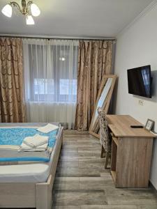 una camera da letto con un letto, una scrivania e una televisione di Casa Giulia 