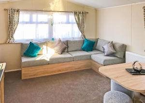 un salon avec un canapé avec des coussins bleus dans l'établissement Beech Hedge, à Coupar Angus