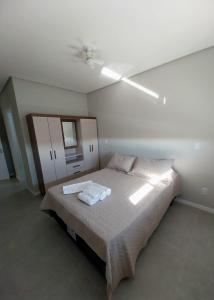 ein Schlafzimmer mit Bett und Deckenventilator in der Unterkunft Modern apartment steps from the beach with amenities in Arroio do Silva