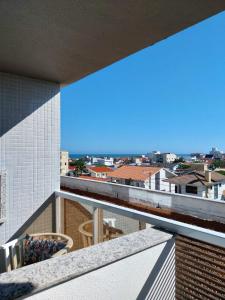 ein Balkon mit Blick auf das Meer in der Unterkunft Modern apartment steps from the beach with amenities in Arroio do Silva