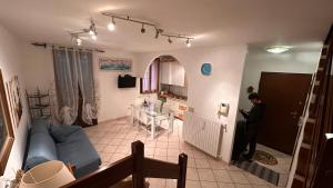 a man standing in a living room with a blue couch at Appartamento " Al ponte degli Sbirri " centro Comacchio in Comacchio