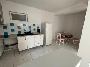 a kitchen with a white refrigerator and a table at Maison Éléphantaisie in Salies-de-Béarn