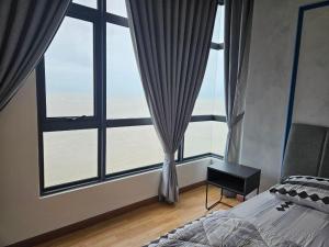 Schlafzimmer mit großen Fenstern, einem Bett und einem Tisch in der Unterkunft House Of 88 in Gua Sai