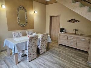 a dining room with a table and chairs and a mirror at Casa Giulia in Jimbolia