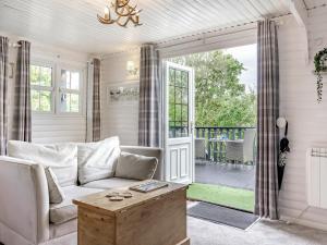 a living room with a couch and a porch at Hygge Cabin in Hexham