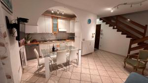 a kitchen with a glass table and white cabinets at Appartamento " Al ponte degli Sbirri " centro Comacchio in Comacchio