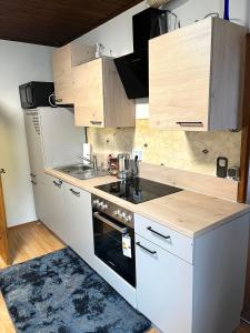 a kitchen with white appliances and wooden cabinets at Stadtwohnung Bruck an der Mur in Bruck an der Mur