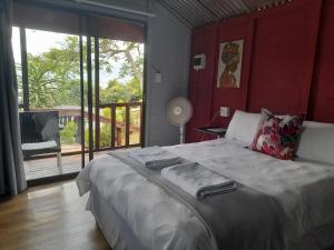 een slaapkamer met een groot bed en een groot raam bij Entendeni Lodge SelfCatering in Inanda