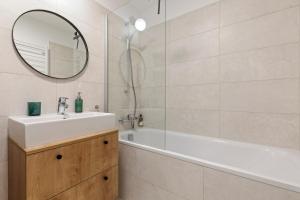 une salle de bain avec un lavabo, une baignoire et un miroir dans l'établissement LAM Concrete AC - Balcony, à Staré Mesto