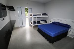 a bedroom with a bed with a blue bedspread at Recanto Ubaduba in Ubatuba