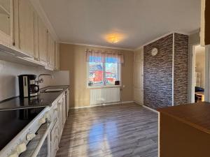 eine Küche mit weißen Schränken und einer Ziegelwand in der Unterkunft Zen Sanctuary in Högsby