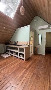 een zolderkamer met een houten vloer en een wastafel bij Cabaña Vacal Wifi, beach front #2 in Uvita