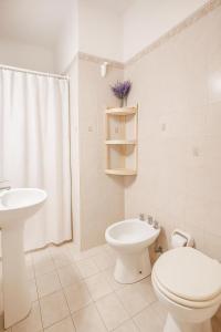 a white bathroom with a toilet and a sink at Hotel Centro SJ in Villa Carlos Paz +58 photos