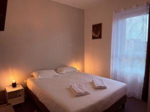 una camera da letto con un letto con due asciugamani sopra di Brit Hotel L'Arrivée Guingamp a Guingamp