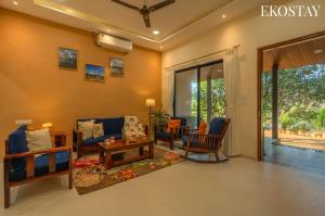 a living room with a couch and chairs at EKOSTAY - Brick Wood in Karjat