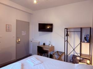 una camera da letto con letto e scrivania e una scrivania deskablish di Brit Hotel L'Arrivée Guingamp a Guingamp