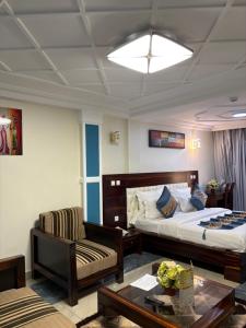 a hotel room with a bed and a chair and a table at H-KREMLIN srl in Yaoundé