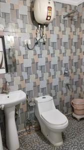 ein Badezimmer mit Toilette und Waschbecken in der Unterkunft Hotel Peeramant Near IGI Airport in Jāmb + 1 Foto