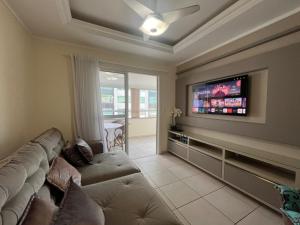 ein Wohnzimmer mit Sofa und Flachbildfernseher in der Unterkunft Ótima Localização!!! Apartamento De Frente No Centro De Capão Da Canoa in Capão da Canoa