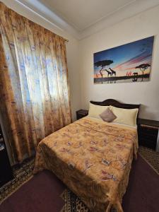 a bedroom with a bed and a painting on the wall at Marrakech plus in Marrakesh