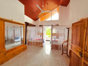 ein großes Zimmer mit zwei Betten und einem Fenster in der Unterkunft Lilly Guest Inn in Haputale