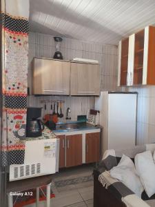a kitchen with wooden cabinets and a white refrigerator at Sobrados pertinho do mar in Tramandaí