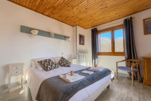 een slaapkamer met een groot bed en een raam bij Logis Hôtels La Crémaillère in Saint-Bonnet-en-Champsaur