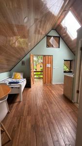 een slaapkamer met een bed en een houten vloer bij Cabaña Vacal Wifi, beach front #2 in Uvita