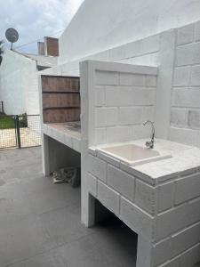 eine Betontheke mit einem Waschbecken auf einer Terrasse in der Unterkunft Corazón de Buey in Gualeguaychú + 26 Fotos