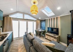 ein Wohnzimmer mit Sofa und Fernseher in der Unterkunft Snainton Luxury Lodges in Ebberston + 8 Fotos