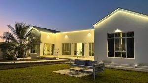 a white house with a bench in the yard at Riva chalet in Badīyah