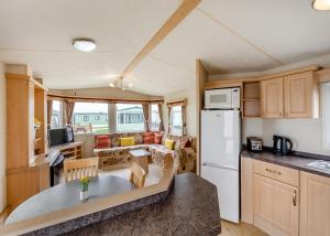 eine Küche und ein Wohnzimmer eines Wohnwagens in der Unterkunft Rowanbank Caravan Park in Beckfoot