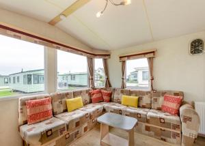 ein Wohnzimmer mit einem Sofa und bunten Kissen in der Unterkunft Rowanbank Caravan Park in Beckfoot + 24 Fotos