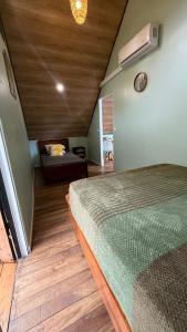 een slaapkamer met een bed en een bank in een kamer bij Cabaña Vacal Wifi, beach front #2 in Uvita +22 foto's