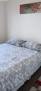 a bedroom with a bed with a white comforter at A pasos de Ruta Cinco y Universidad in Talca