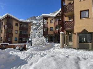 ein Schneehaufen vor einem Gebäude in der Unterkunft Le Landry - 115m2 Label 5 Cimes - Pistes à 3min chemin piéton - Borne VE in Lanslevillard