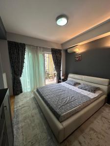 ein Schlafzimmer mit einem Bett und einem großen Fenster in der Unterkunft Apartament Modern & Spatios - La 2 minute de Mare in Mamaia Nord – Năvodari