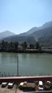 ein Fluss mit neben einer Brücke geparkten Autos in der Unterkunft Hotel Lake View Paradise in Uttarkāshi + 18 Fotos