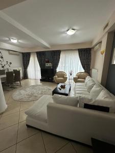 ein großes Wohnzimmer mit einem weißen Sofa und Stühlen in der Unterkunft Apartament Modern & Spatios - La 2 minute de Mare in Mamaia Nord – Năvodari