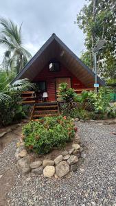 een klein rood huisje met wat bloemen ervoor bij Cabaña Vacal Wifi, beach front #2 in Uvita
