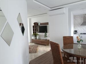 a living room with a table and chairs and a television at TIM Haute standing appartment S2, center Monastir in Monastir